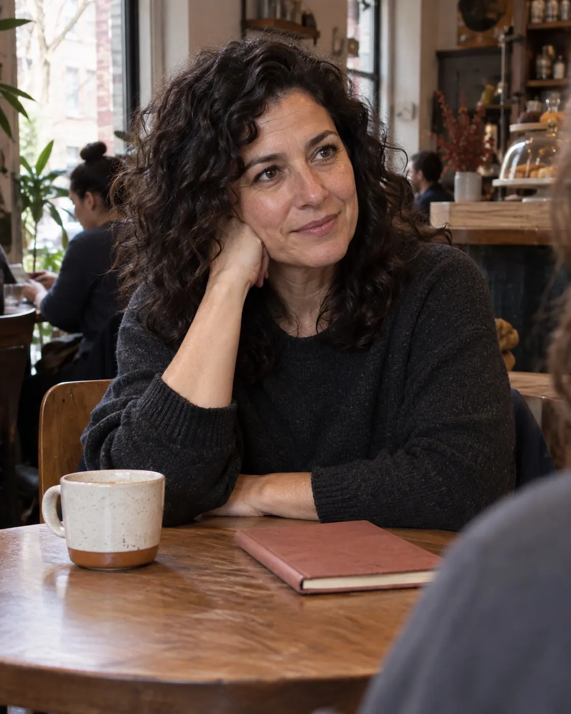 A person listening thoughtfully during a café conversation